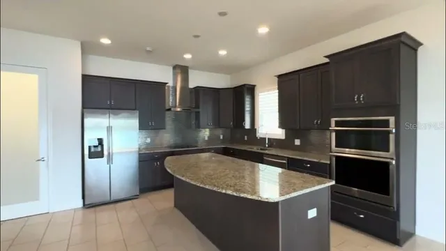 a kitchen with kitchen island granite countertop stainless steel appliances and sink