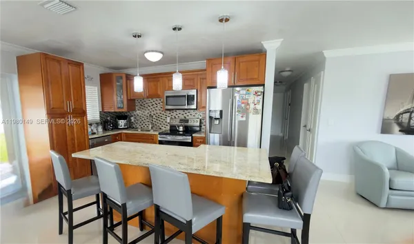 a kitchen with a dining table chairs and refrigerator