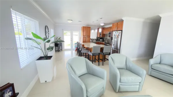 a living room with furniture and a dining table with kitchen view