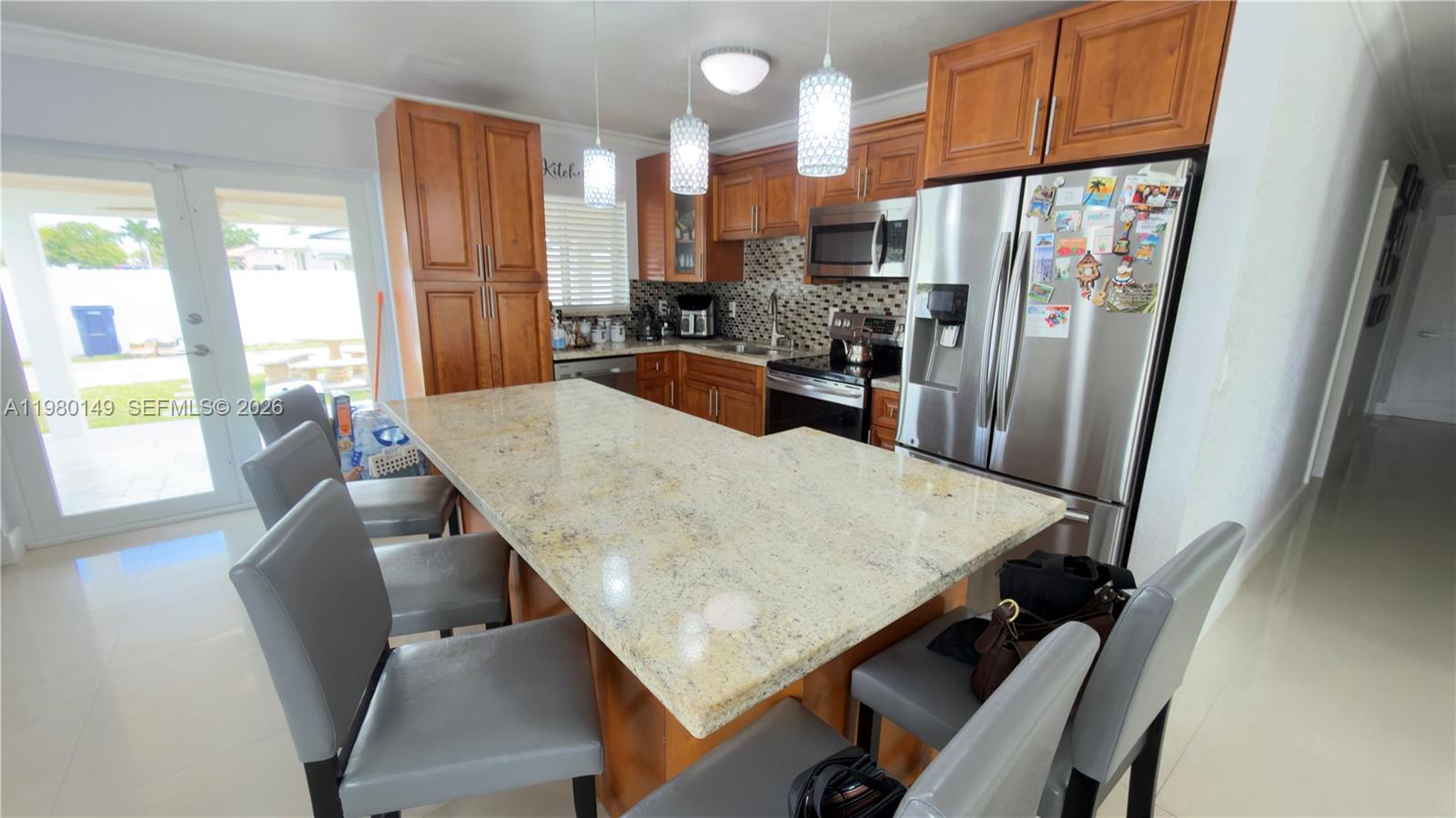 30001 Southwest 153rd Avenue Homestead, FL 33033 - Photo 17 of 55 a kitchen with stainless steel appliances wooden floor dining table and chairs