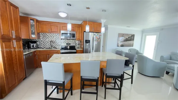 a dining room with furniture a large window and stainless steel appliances