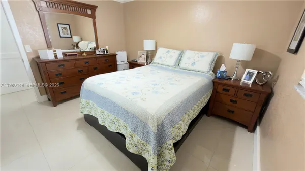 a bed sitting in a bedroom next to a bathroom sink