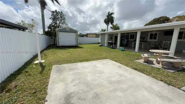 a view of a house with a yard and sitting area