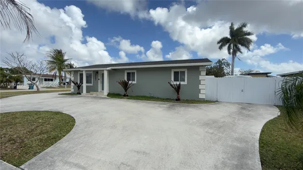 front view of house with a yard and potted plants