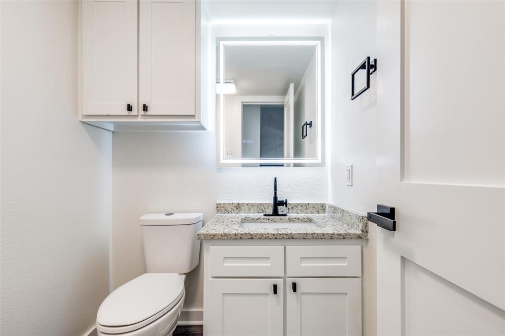 2228 Colony Court Dallas, TX 75235 - Photo 7 of 14 a bathroom with a granite countertop toilet sink and mirror