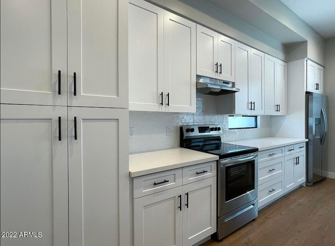 3215 East Flower Street, Unit 10 Phoenix, AZ 85018 - Photo 32 of 50 a kitchen with white cabinets and white appliances