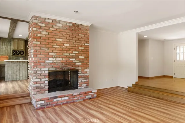 a view of empty room with wooden floor and fireplace