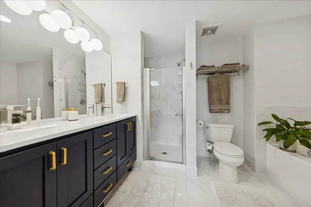 a spacious bathroom with a double vanity sink toilet and shower