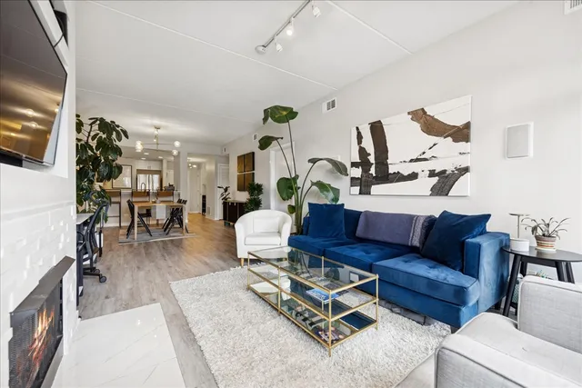 a living room with furniture kitchen view and a wooden floor
