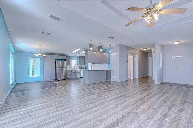 a view of an empty room and a kitchen