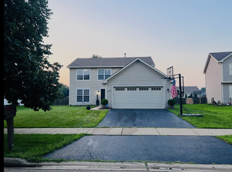 a view of a house with a yard and large tree