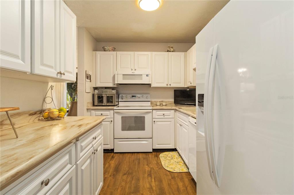 672 White Pine Tree Road, Unit 57 Venice, FL 34285 - Photo 12 of 57 a kitchen with granite countertop white cabinets and white appliances