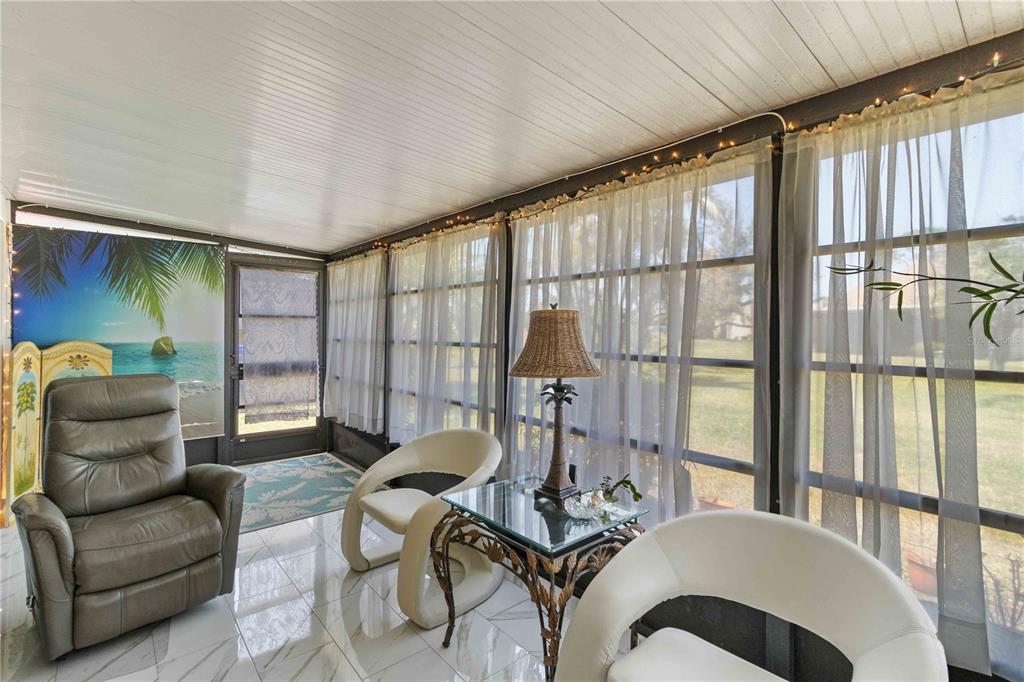 672 White Pine Tree Road, Unit 57 Venice, FL 34285 - Photo 15 of 57 a living room with furniture and a floor to ceiling window
