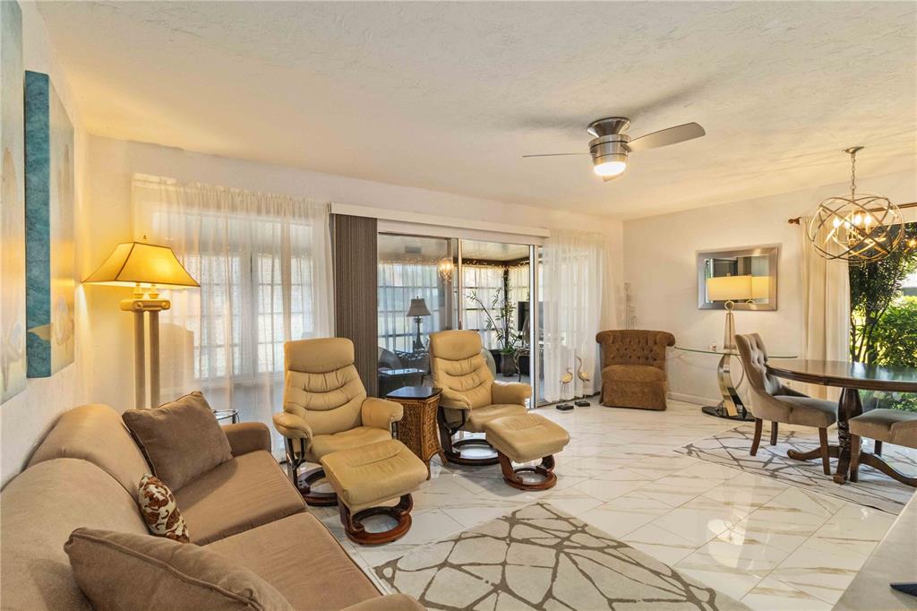 672 White Pine Tree Road, Unit 57 Venice, FL 34285 - Photo 4 of 57 a living room with furniture and a chandelier