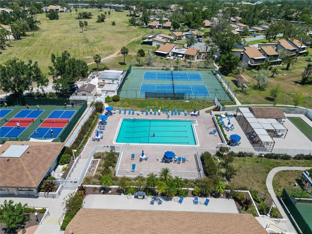 672 White Pine Tree Road, Unit 57 Venice, FL 34285 - Photo 44 of 57 an aerial view of a tennis ground and a cars park side of the road