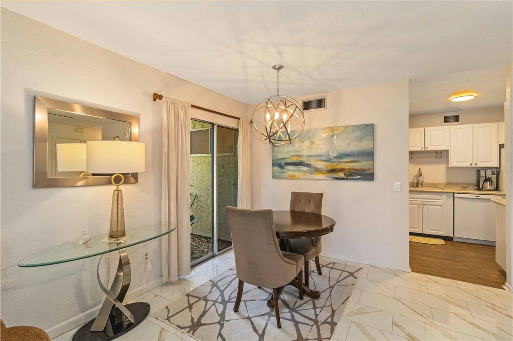 672 White Pine Tree Road, Unit 57 Venice, FL 34285 - Photo 7 of 57 a view of a dining room and kitchen with a chandelier
