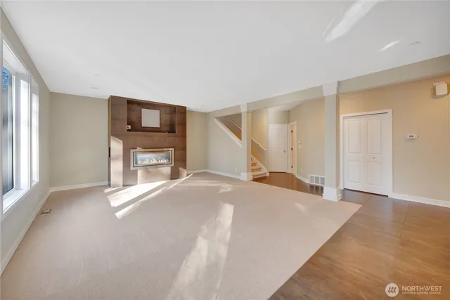 a view of empty room with a fireplace and a window