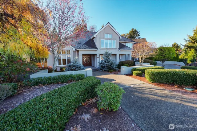 a front view of a house with a yard and potted plants