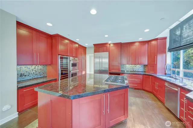 a kitchen with stainless steel appliances granite countertop a stove a sink and a microwave