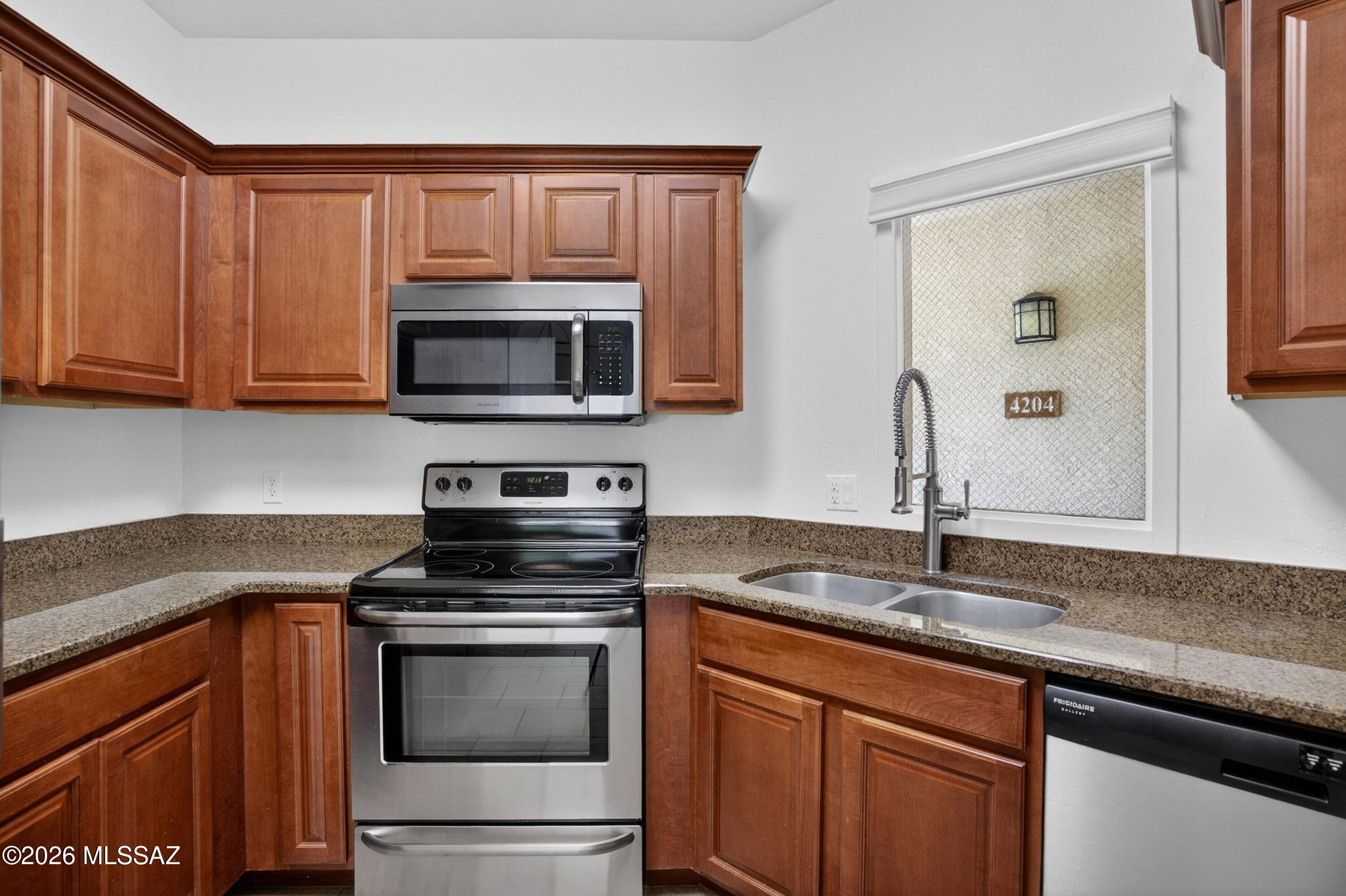 2550 East River Road, Unit 4204 Tucson, AZ 85718 - Photo 14 of 36 a kitchen with granite countertop a sink and a stove top oven with granite countertops