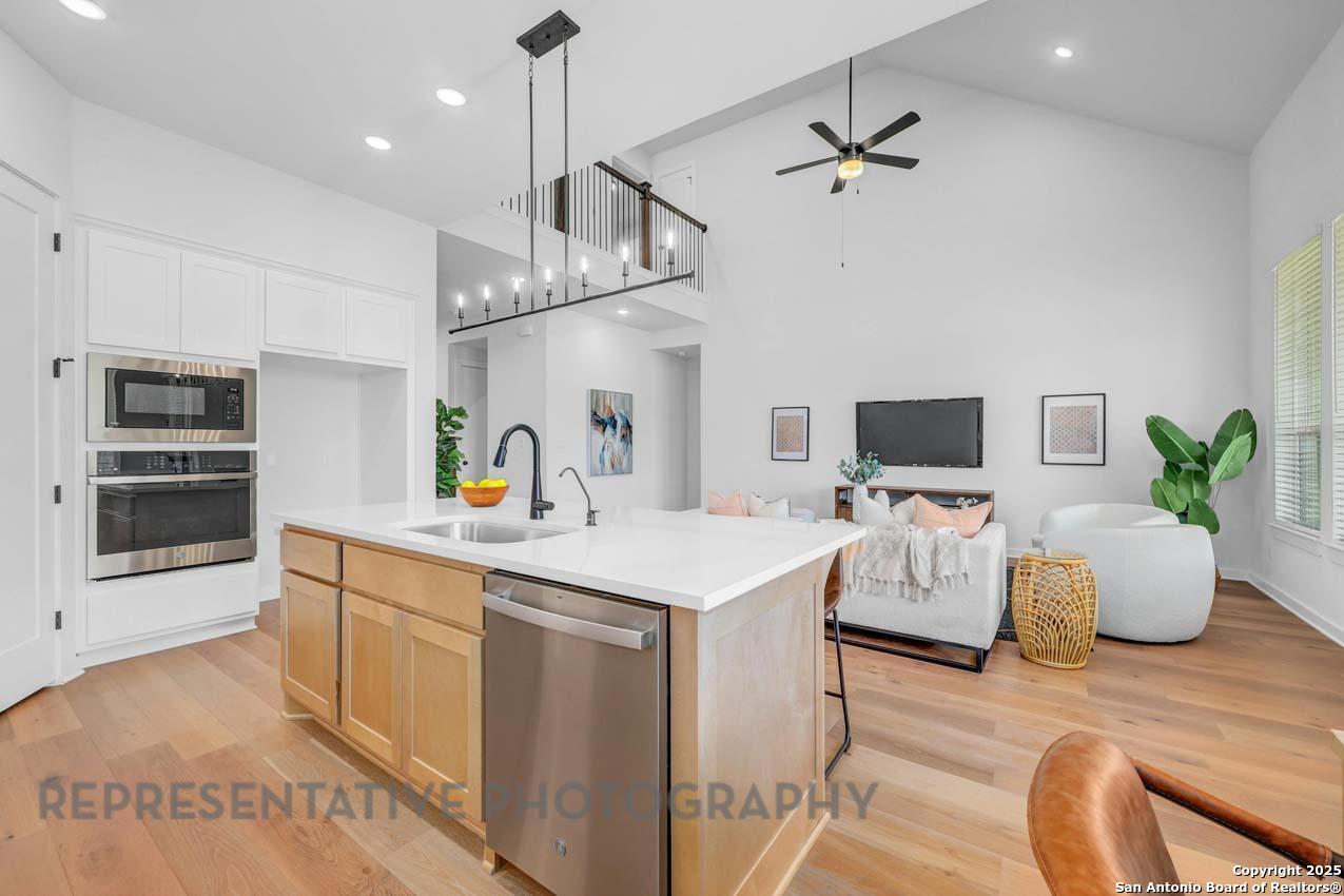 148 Spanish Oak Castroville, TX 78009 - Photo 3 of 19 a kitchen view with microwave a stove and white cabinets
