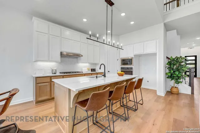 a kitchen with a table chairs sink and cabinets