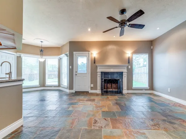 a view of an empty room with a fireplace and a window