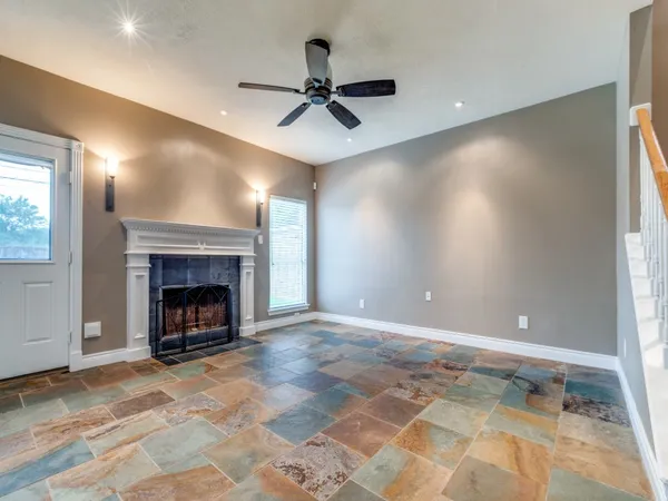 a view of an empty room with a fireplace and a window
