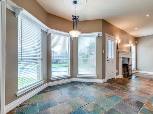 a view of an empty room with a window and chandelier