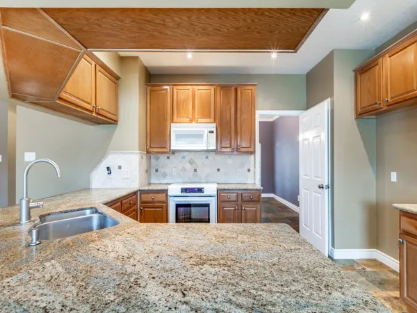 a kitchen with stainless steel appliances granite countertop a refrigerator sink and cabinets