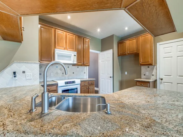 a kitchen with kitchen island a sink stove and refrigerator