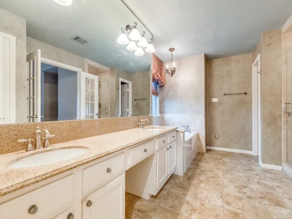 a spacious bathroom with a granite countertop sink a toilet a mirror and shower