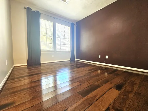 a view of room with window and wooden floor