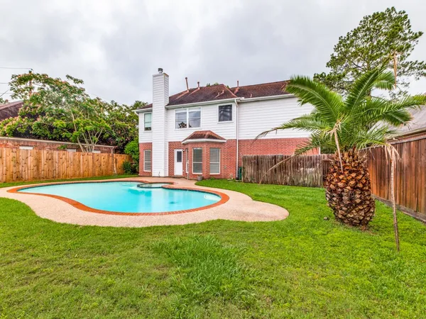 a view of a house with a swimming pool and a yard