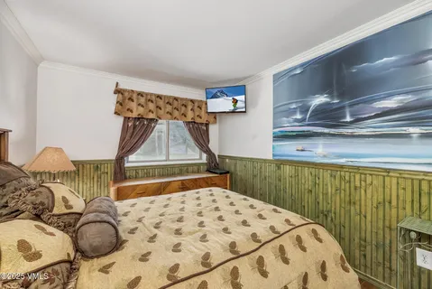 a bedroom with a bed and a painting on the wall