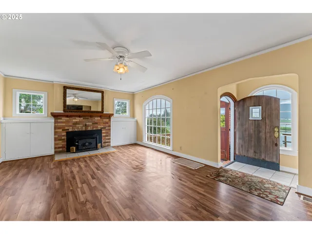 a view of empty room with fireplace and wooden floor
