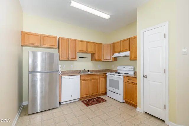 a kitchen with stainless steel appliances granite countertop a refrigerator and a stove top oven