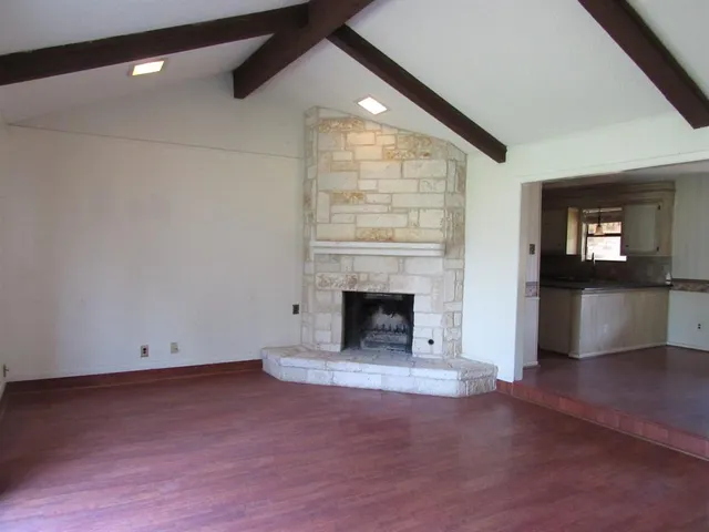 an empty room with windows and fireplace