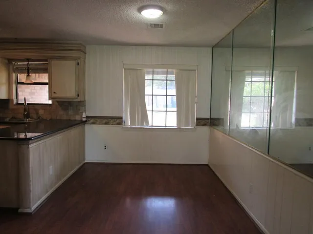 a view of a kitchen with wooden floor and a window