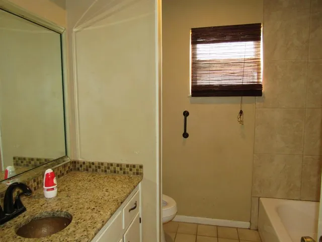 a bathroom with a granite countertop sink and a shower