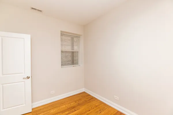 a view of a room with wooden floor and a window