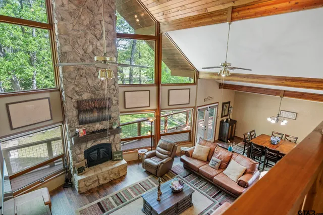 a living room with furniture a flat screen tv and a floor to ceiling window