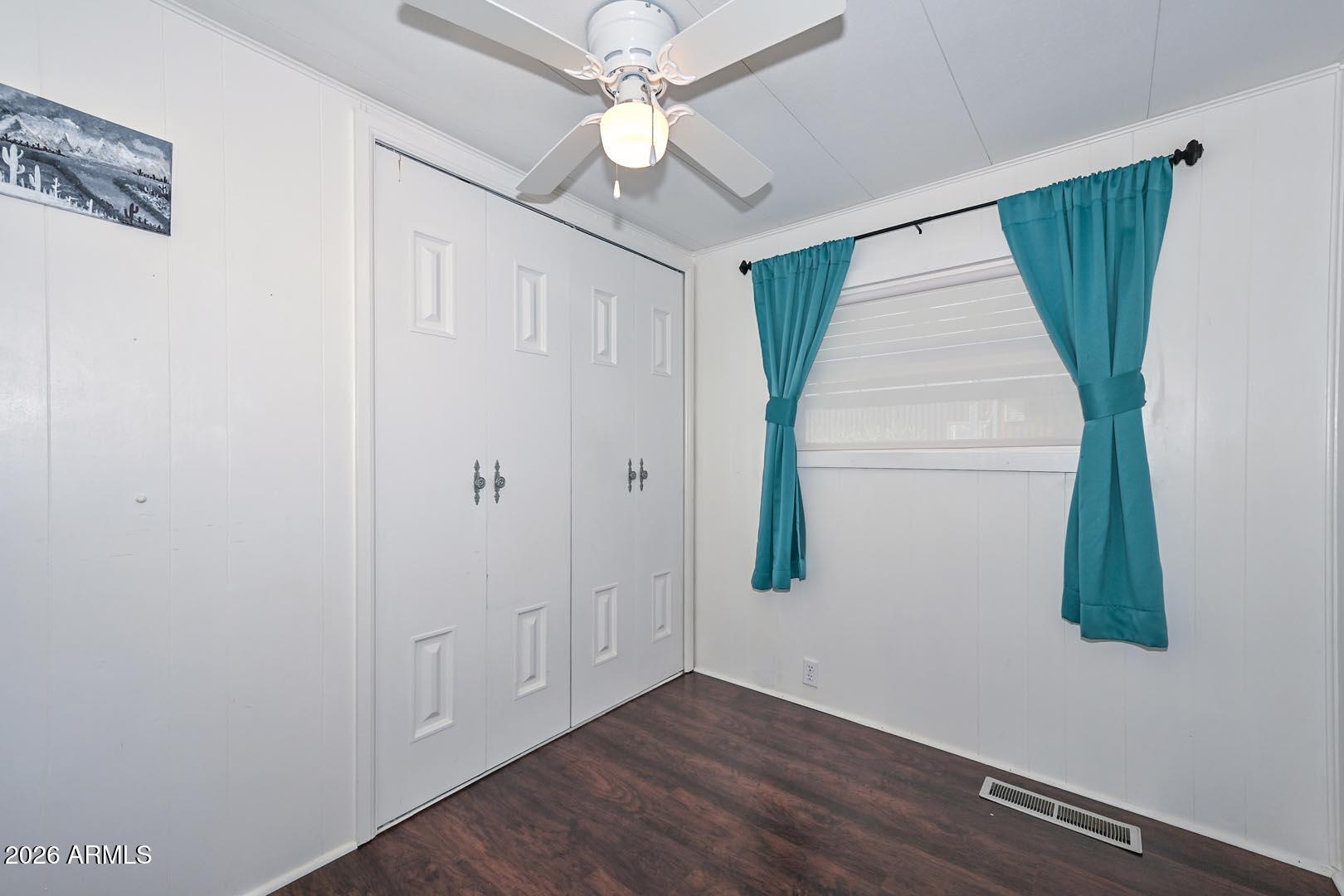 16225 North Cave Creek Road, Unit 79 Phoenix, AZ 85032 - Photo 11 of 32 an empty room with wooden floor fan and windows