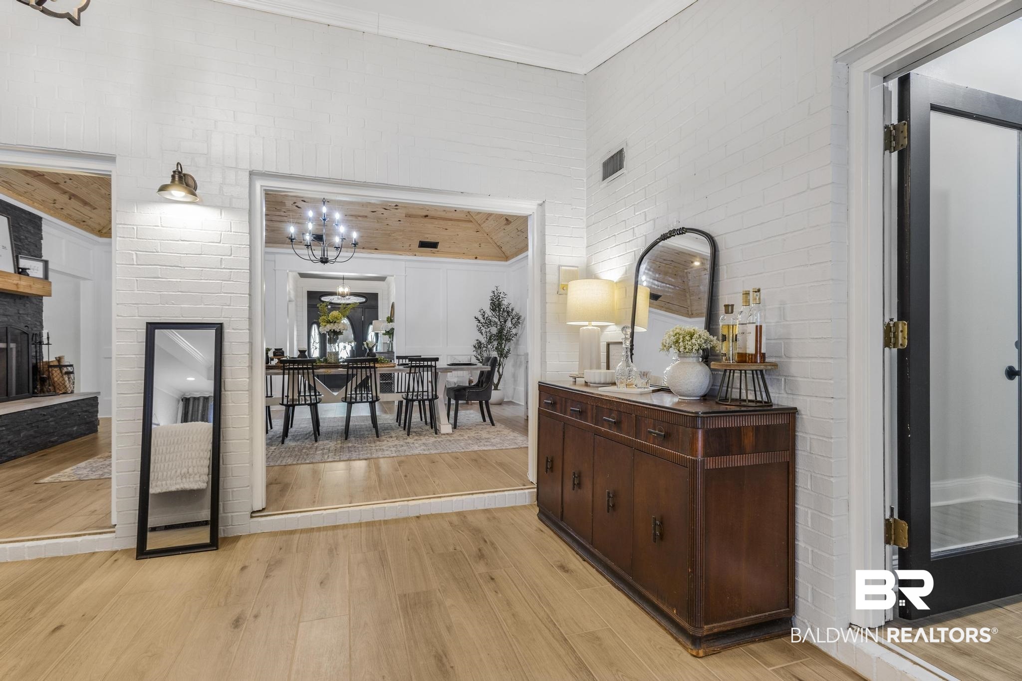 83 Caisson Trace Daphne, AL 36527 - Photo 29 of 63 Light wood-finish flooring throughout, featuring painted brick walls and a dark wood console table