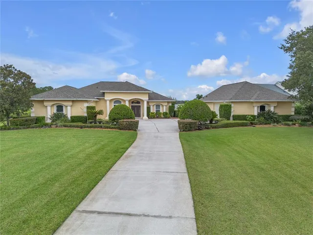 an aerial view of lake residential house with outdoor space and trees all around