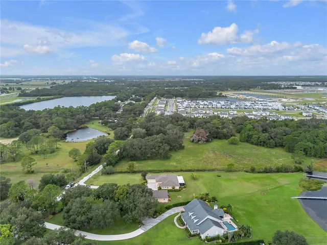 an aerial view of a house with a garden and lake view