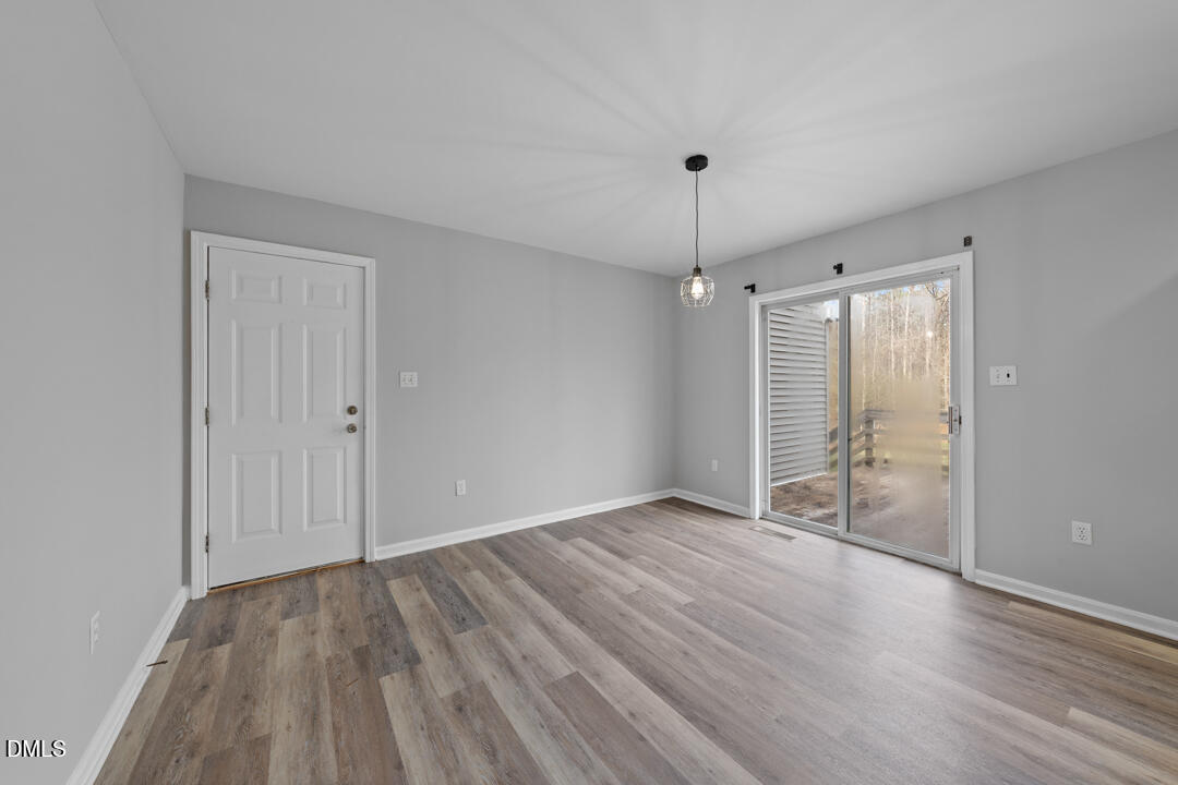 5523 Old Noble Road Cedar Grove, NC 27231 - Photo 6 of 16 an empty room with wooden floor and windows