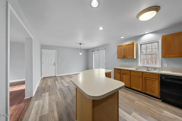 a kitchen with a sink dishwasher a stove and a microwave with wooden floor
