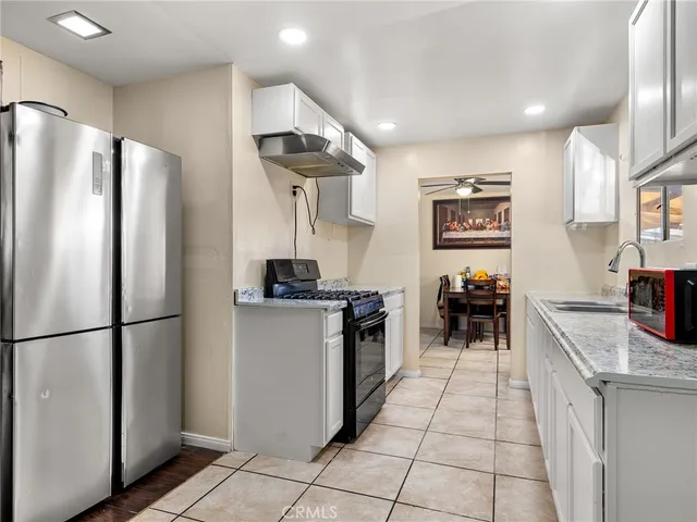a kitchen with stainless steel appliances granite countertop a refrigerator sink and stove