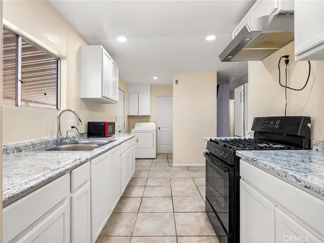 a kitchen with a sink a stove and cabinets